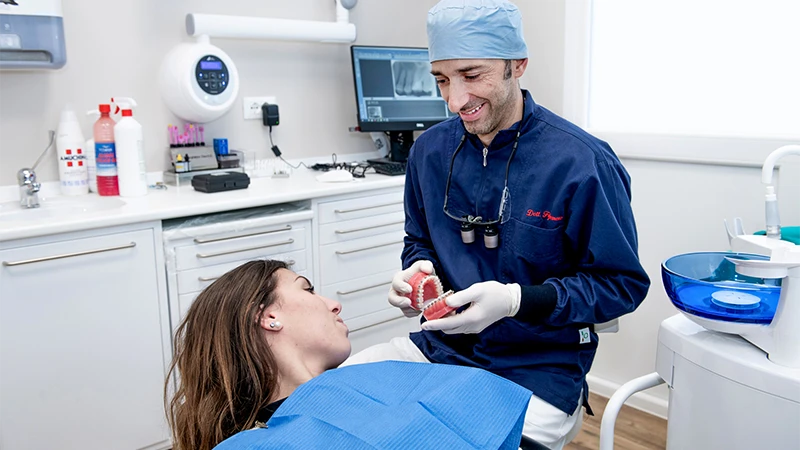 Dentista Enrico Figliomeno mostra apparecchio dentale fisso ad una paziente