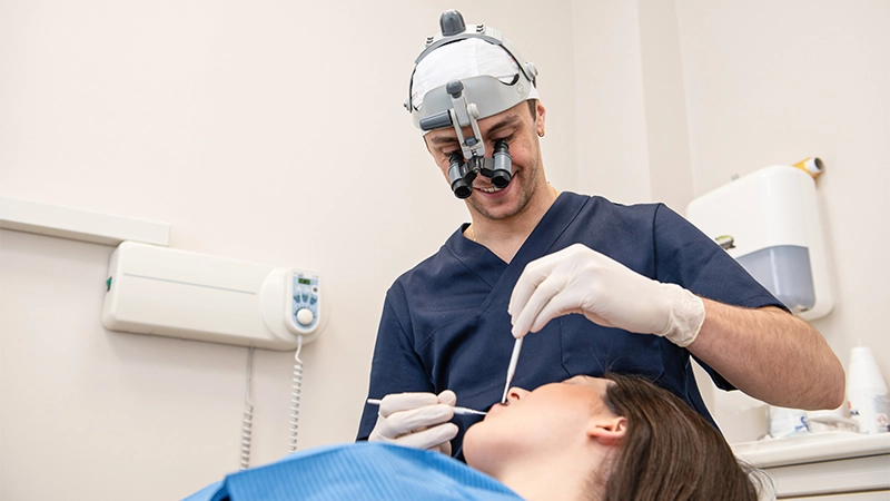 Dottore dello Studio Dentistico Figliomeno esegue un intervento di chirurgia orale su una paziente