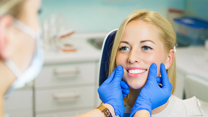 Dottore controlla la funzionalità e l'estetica dei denti di una paziente